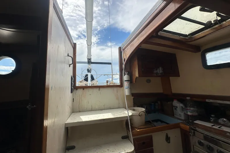 Slide: The Image of Interior view of 1994 Pilot Schooner Leopard sailboat, featuring wooden cabinetry and nautical equipment. - 69