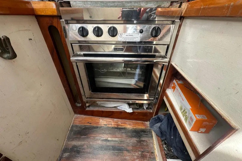 Slide: The Image of Stainless steel oven in 1994 Pilot Schooner Leopard's compact wooden kitchen area. - 73
