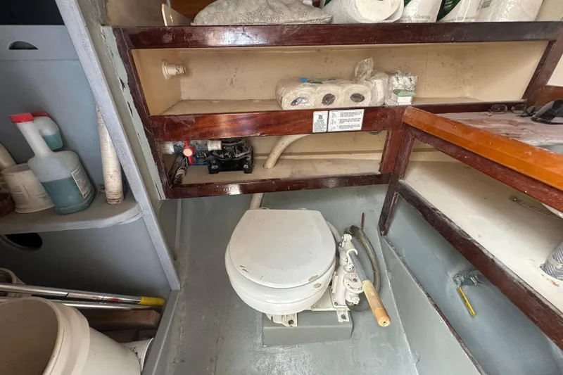 Slide: The Image of Interior of 1994 Pilot Schooner Leopard with marine toilet and storage shelves. - 83
