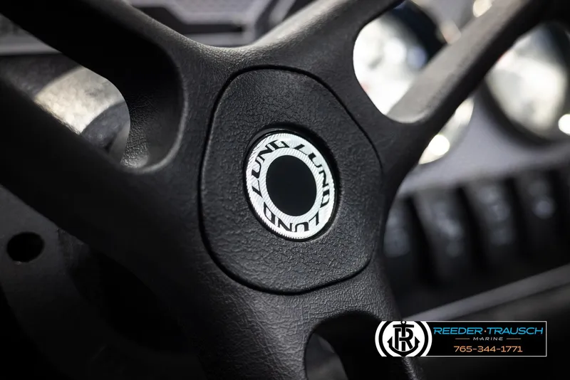 Slide: The Image of Steering wheel of 2025 Lund Rebel XL SS boat, featuring Reeder-Trausch Marine logo. - 20