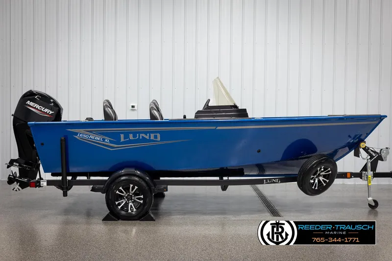Slide: The Image of 2025 Lund Rebel XL SS boat in blue, side view with Mercury engine, on trailer. - 3