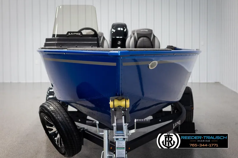 Slide: The Image of 2025 Lund Rebel XL SS boat in blue on trailer, displayed indoors. - 6
