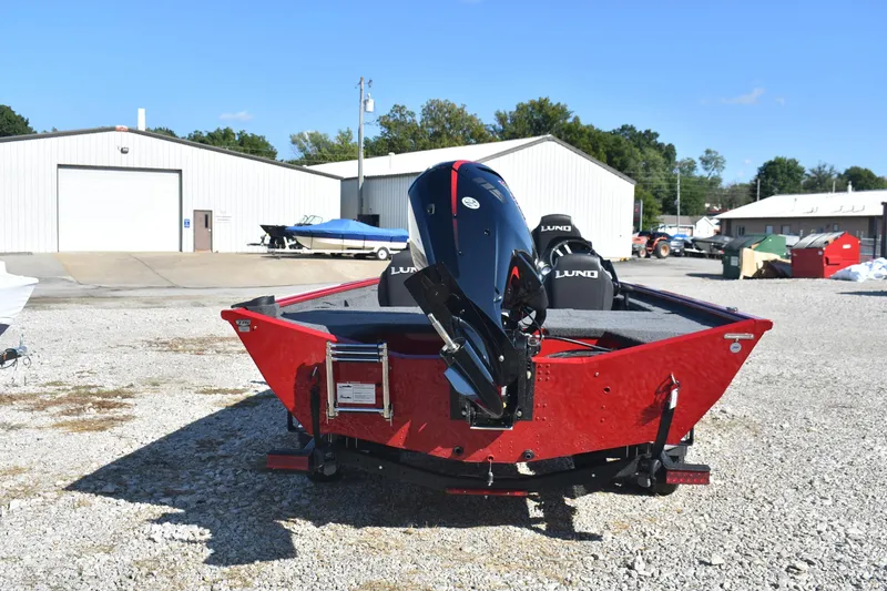 Slide: The Image of 2026 Lund 1875 Renegade boat with outboard motor in a gravel lot. - 3