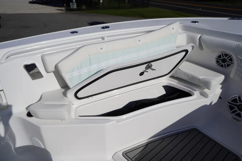 Slide: The Image of 2026 Tidewater 272 LXF boat with open storage compartment and cushioned seating. - 14