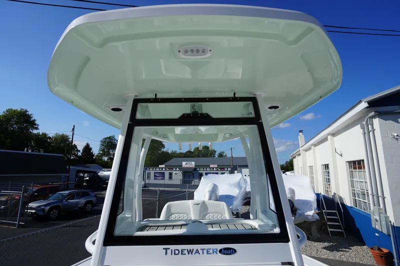 Slide: The Image of 2026 Tidewater 272 LXF boat with hardtop, parked outdoors under clear blue sky. - 24