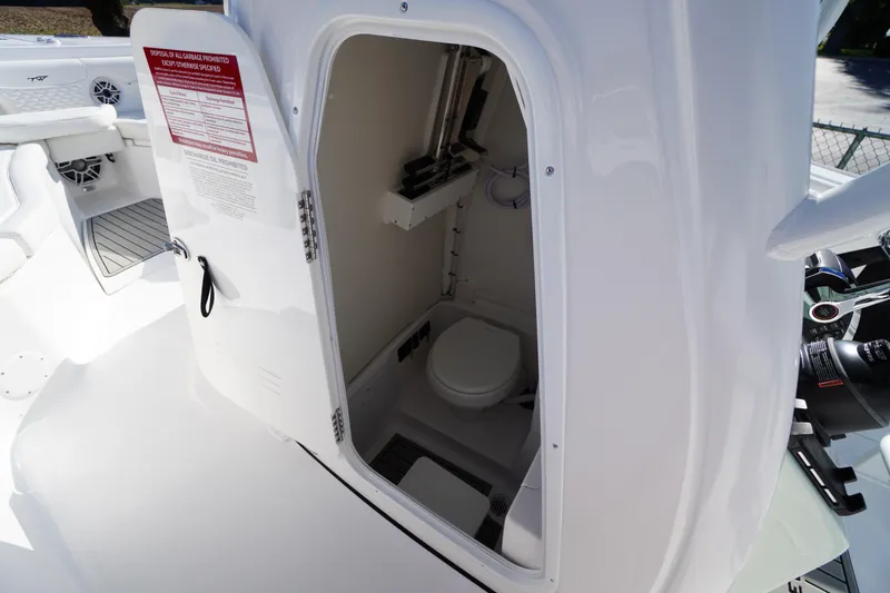 Slide: The Image of 2026 Tidewater 272 LXF boat interior with open door revealing compact marine toilet. - 26