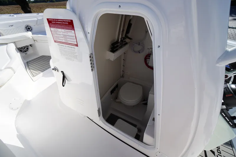 Slide: The Image of 2026 Tidewater 272 LXF boat interior with open door revealing compact marine toilet. - 27