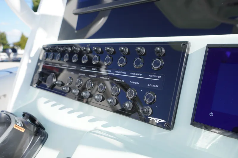 Slide: The Image of Control panel of 2026 Tidewater 272 LXF boat with various switches and buttons. - 36