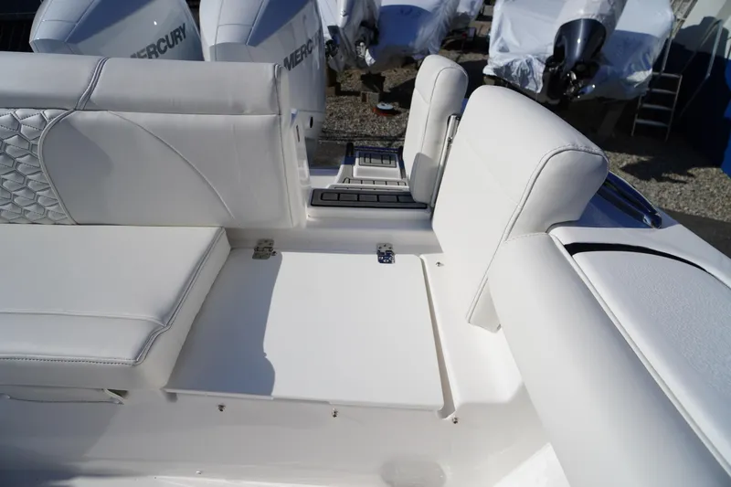 Slide: The Image of 2026 Tidewater 272 LXF boat interior with white cushioned seating and Mercury engines. - 58