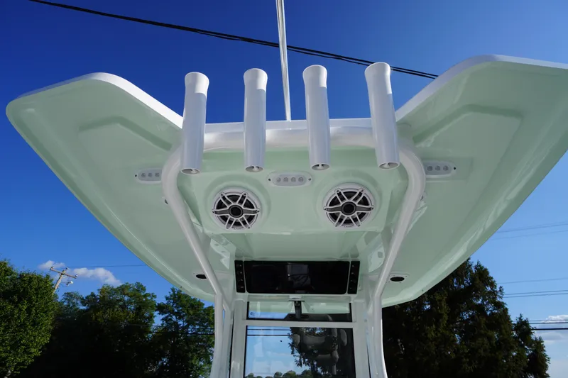 Slide: The Image of 2026 Tidewater 272 LXF boat with rod holders and speakers under a clear blue sky. - 67