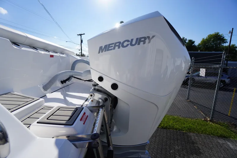 Slide: The Image of 2026 Tidewater 272 LXF boat with Mercury outboard engine, docked under clear blue sky. - 71
