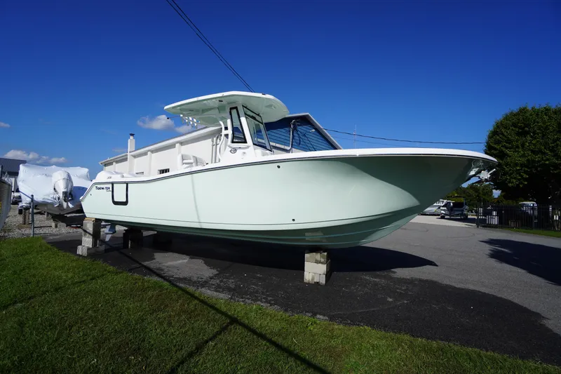 Slide: The Image of 2026 Tidewater 272 LXF boat on display, elevated on blocks, under clear blue sky. - 85