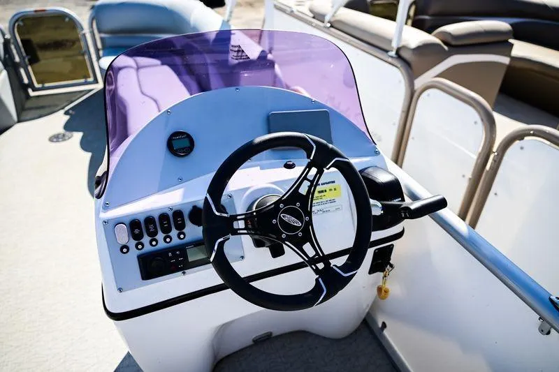 Slide: The Image of 2023 Aloha Pontoon Mahalo 23 steering console with controls and purple windshield. - 7