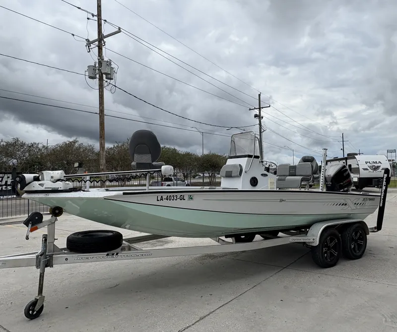 Slide: The Image of 2020 Xpress H20 B boat on trailer, parked outdoors under cloudy sky. - 12