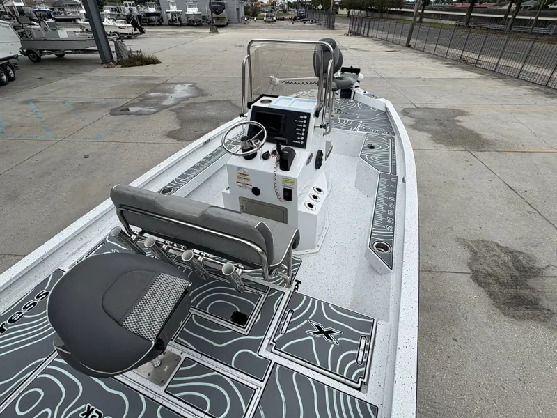 Slide: The Image of 2020 Xpress H20 B boat with modern console and seating, parked on concrete. - 4