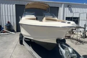 Slide: The Image of 2022 Scout 210 Dorado boat on trailer, parked outside a metal building. - 3