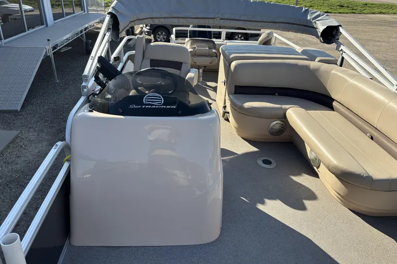 Slide: The Image of 2017 Sun Tracker Fishin' Barge 22 XP3 interior with beige seating and steering console. - 15