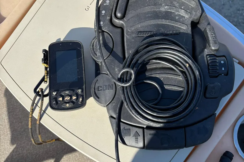 Slide: The Image of 2017 Sun Tracker Fishin' Barge 22 XP3 control panel with electronic device and coiled cable. - 22