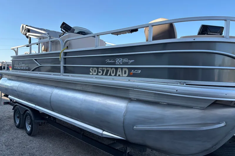 Slide: The Image of 2017 Sun Tracker Fishin' Barge 22 XP3 pontoon boat on trailer, side view. - 4
