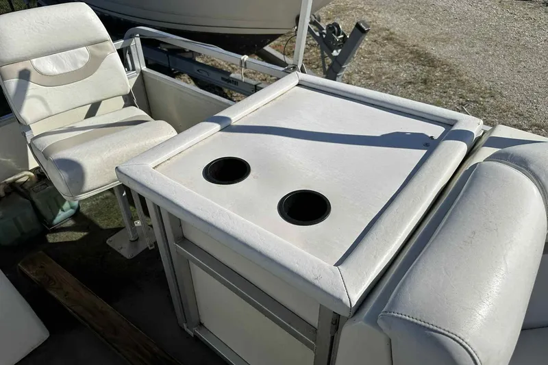 Slide: The Image of 2003 Beachcomber 24 Fish & Play boat interior with seating and cup holders. - 12