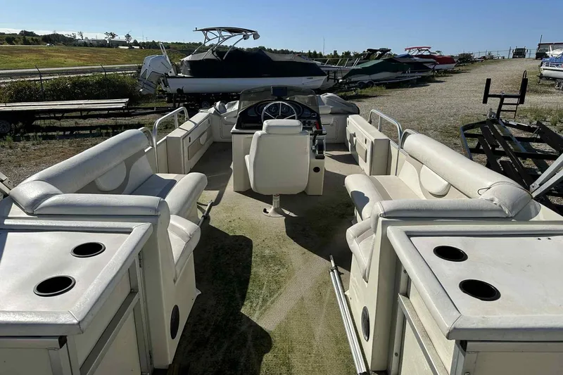 Slide: The Image of 2003 Beachcomber 24 Fish & Play pontoon boat interior with seating and console. - 13