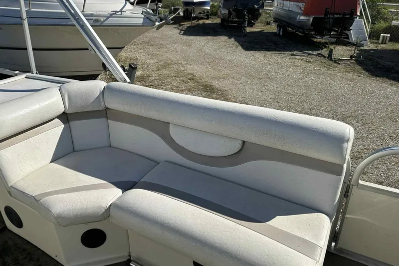 Slide: The Image of 2003 Beachcomber 24 Fish & Play boat interior seating in a marina setting. - 4