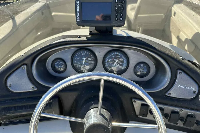 Slide: The Image of Dashboard of a 2003 Beachcomber 24 Fish & Play boat with gauges and Lowrance device. - 5