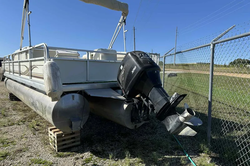 Slide: The Image of 2003 Beachcomber 24 Fish & Play pontoon boat with outboard motor, parked on gravel. - 7