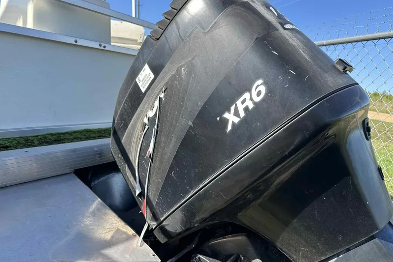 Slide: The Image of Outboard motor on 2003 Beachcomber 24 Fish & Play boat, labeled XR6. - 9