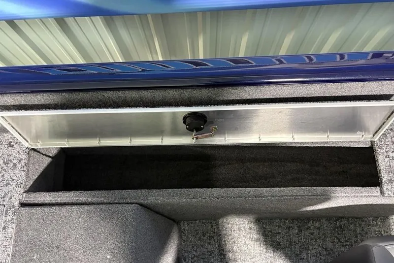 Slide: The Image of Storage compartment in 2026 Tracker Pro Guide V-175 Combo boat, featuring carpeted interior. - 28