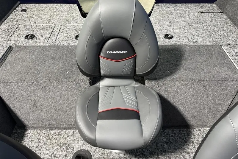 Slide: The Image of 2026 Tracker Pro Guide V-175 Combo boat seat, gray with red accents, on carpeted deck. - 30