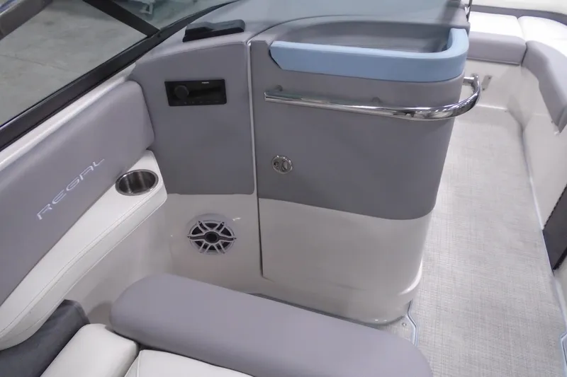 Slide: The Image of 2026 Regal LX6 boat interior with gray seating, cup holder, and speaker. - 14