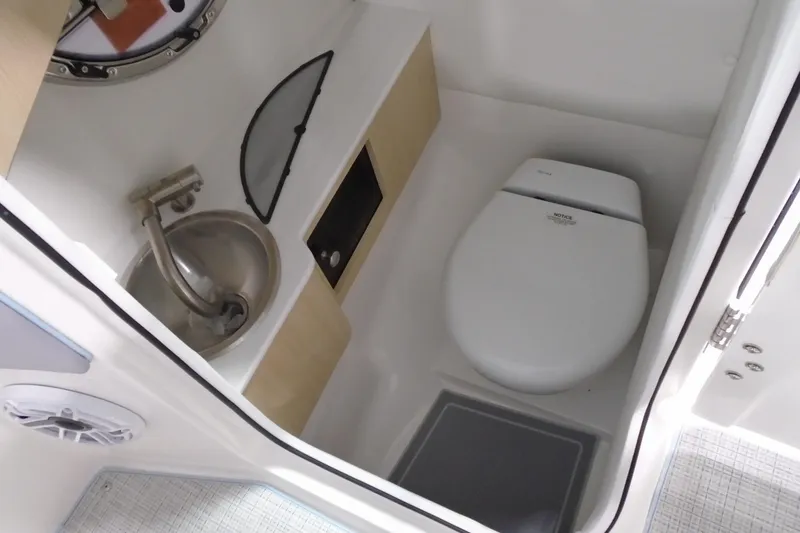 Slide: The Image of 2026 Regal LX6 boat bathroom with toilet, sink, and storage compartment. - 15