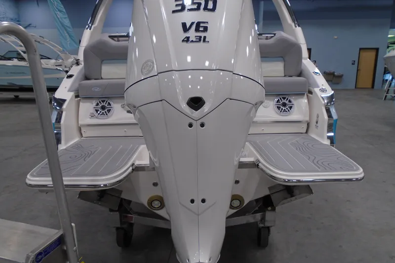 Slide: The Image of 2026 Regal LX6 boat with V6 engine, displayed indoors, featuring swim platforms and seating. - 23