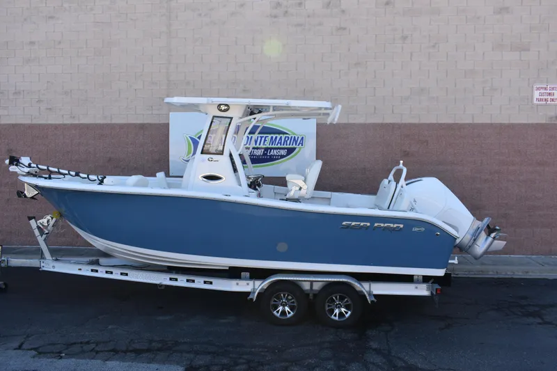 The Image of 2025 Sea Pro 245 Sandbar boat on trailer, blue hull, parked outside. - 0