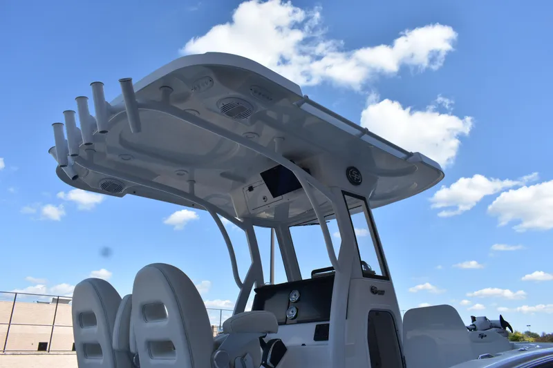 Slide: The Image of 2025 Sea Pro 245 Sandbar boat with T-top under a clear blue sky. - 29