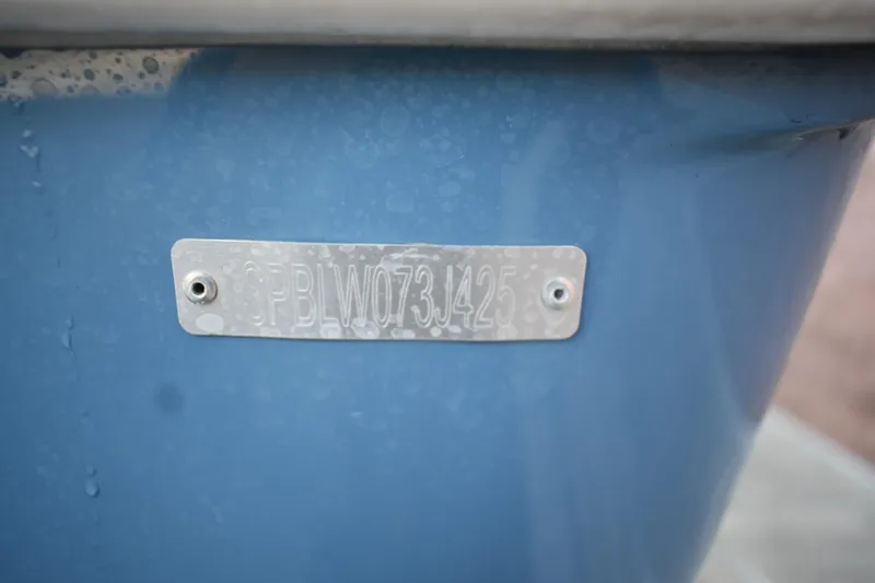 Slide: The Image of 2025 Sea Pro 245 Sandbar boat hull identification number on blue surface. - 30