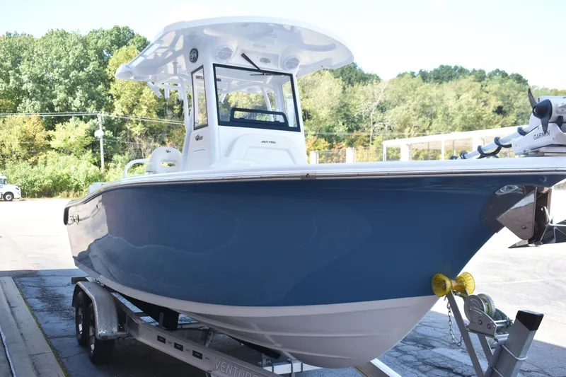 Slide: The Image of 2025 Sea Pro 245 Sandbar boat on trailer, blue hull, parked outdoors. - 5