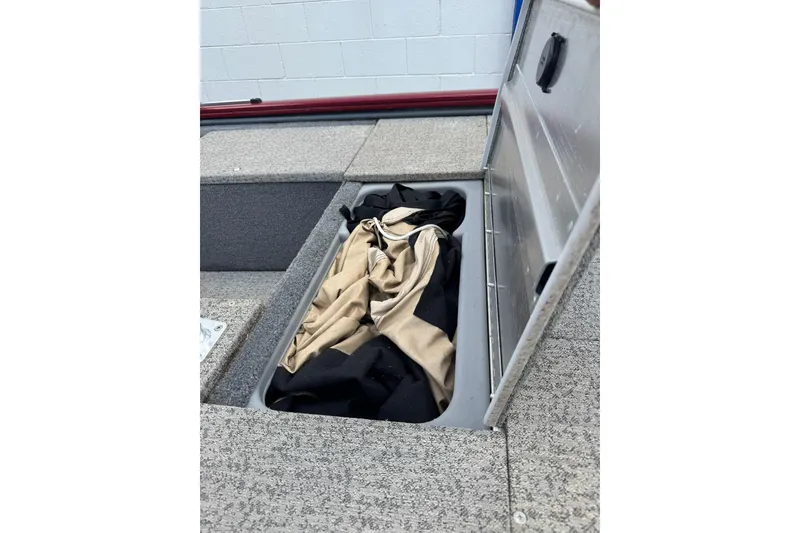 Slide: The Image of Open storage compartment in 2022 Tracker Pro 170 boat with beige and black fabric inside. - 7