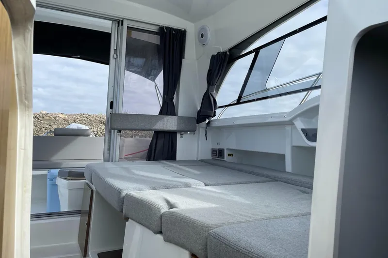 Slide: The Image of Interior of 2020 Beneteau Antares 23 boat with seating and windows. - 13