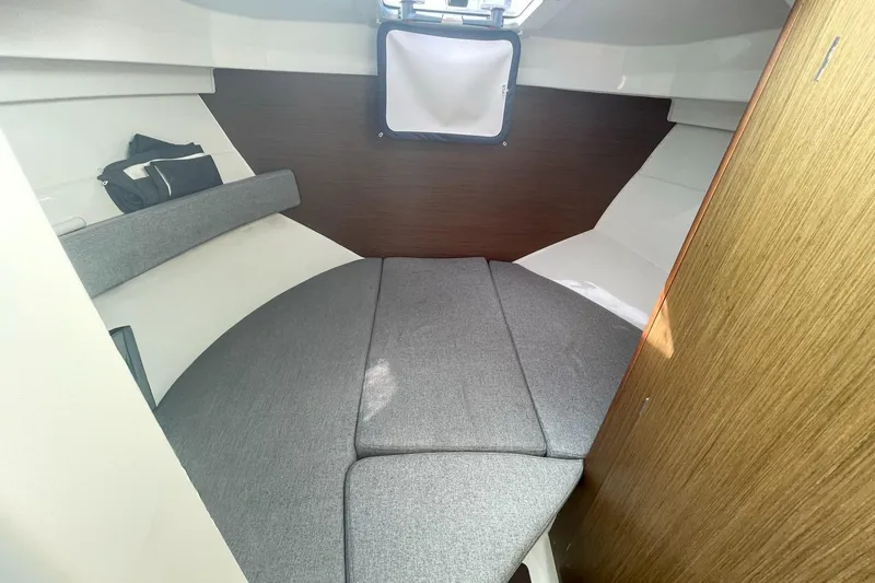 Slide: The Image of Cozy cabin interior of 2020 Beneteau Antares 23 with gray cushions and wood accents. - 15