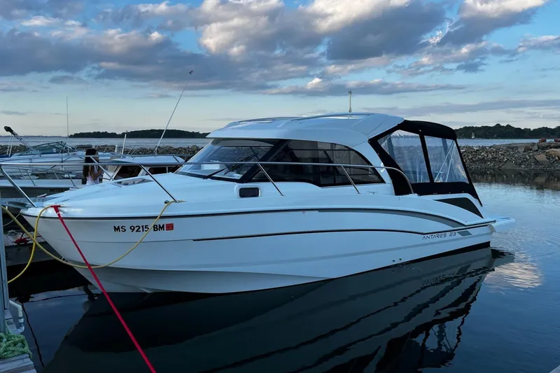 Slide: The Image of 2020 Beneteau Antares 23 boat docked at marina under cloudy sky. - 26