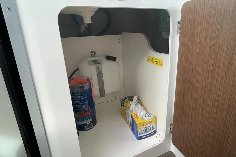 Slide: The Image of Storage compartment in a 2020 Beneteau Antares 23 boat with supplies and equipment. - 30