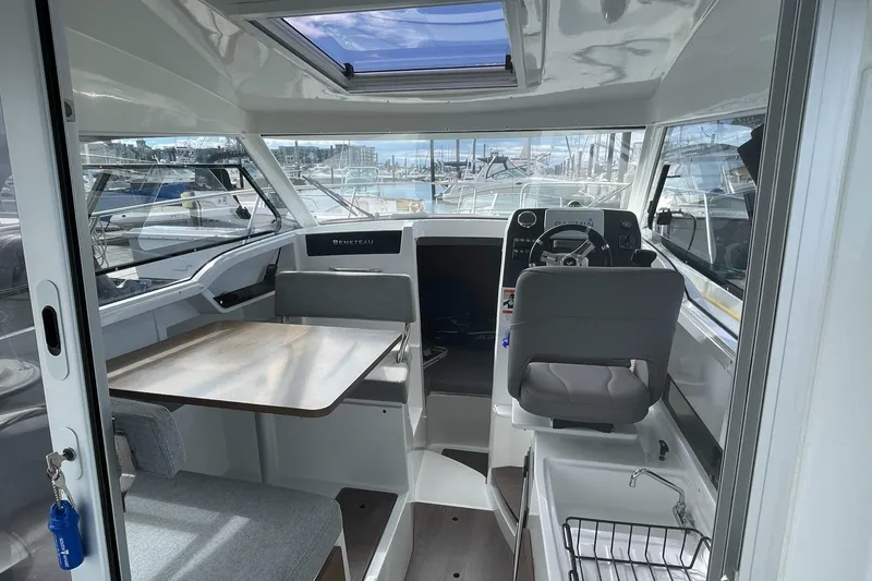Slide: The Image of Interior of 2020 Beneteau Antares 23 boat, featuring helm, seating, and table. - 4