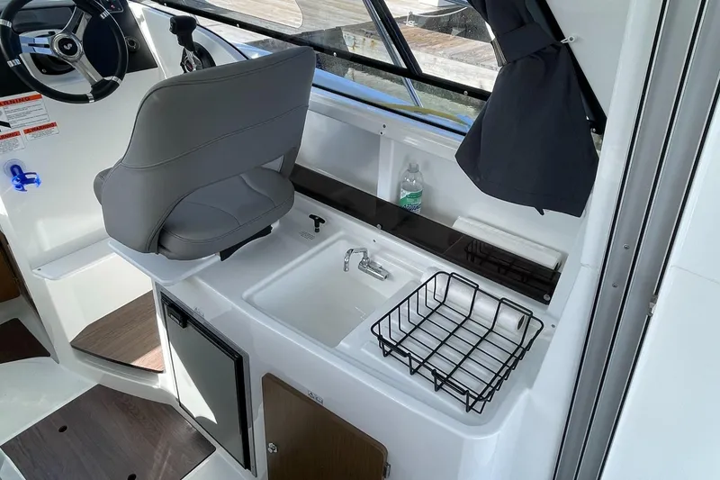 Slide: The Image of Interior of 2020 Beneteau Antares 23 boat with steering wheel, sink, and storage. - 6