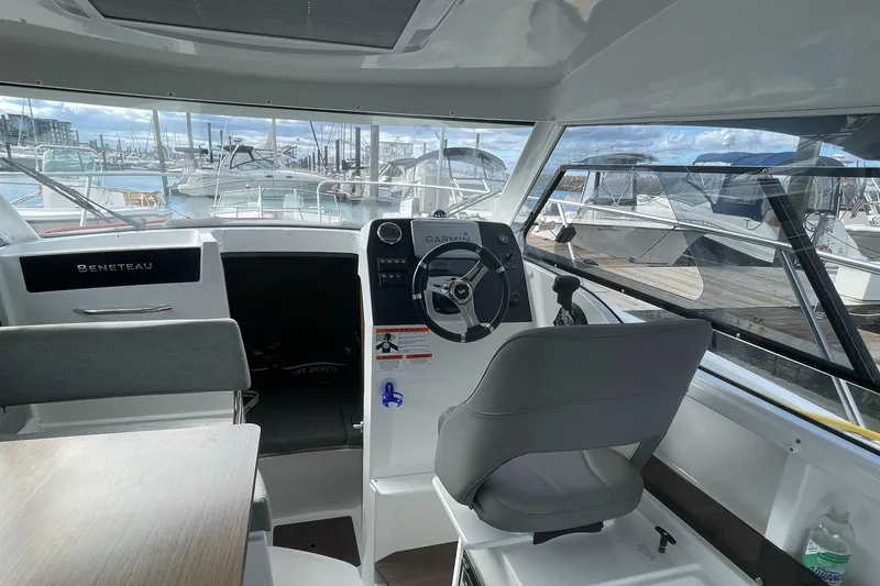 Slide: The Image of Interior of 2020 Beneteau Antares 23 boat with steering wheel and marina view. - 7