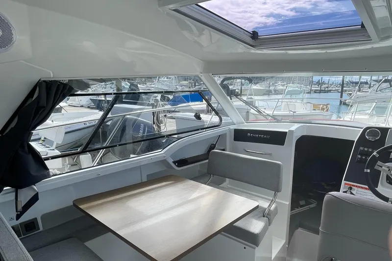Slide: The Image of Interior of 2020 Beneteau Antares 23 boat with seating and table, marina view. - 9