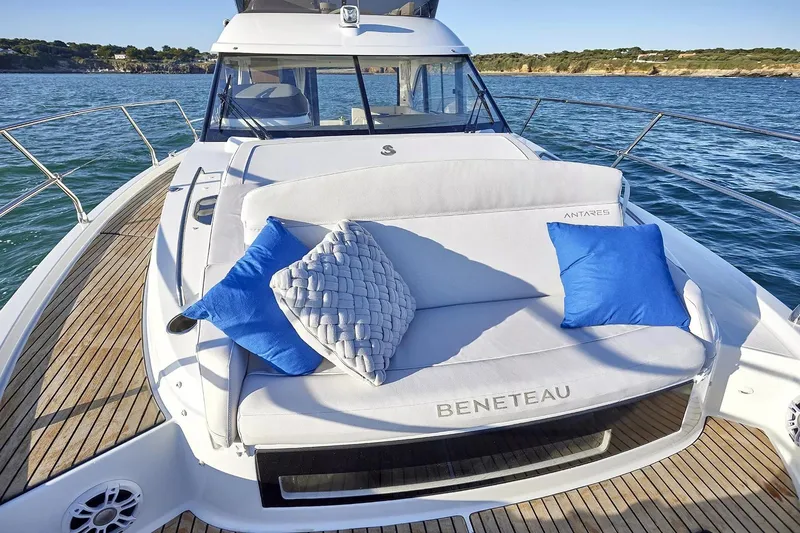 Slide: The Image of 2026 Beneteau Antares 12 yacht with cushioned deck seating and blue pillows on open water. - 7