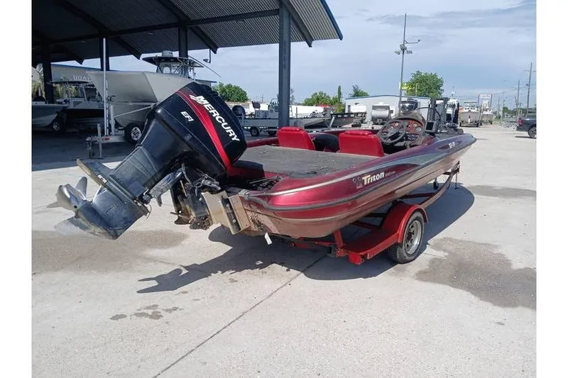 Slide: The Image of 2001 Triton TR19 boat with Mercury engine on a trailer, parked outdoors. - 5