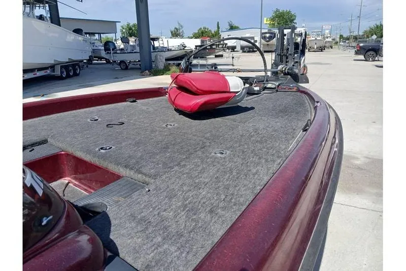 Slide: The Image of 2001 Triton TR19 boat deck with red seat, parked outdoors. - 6
